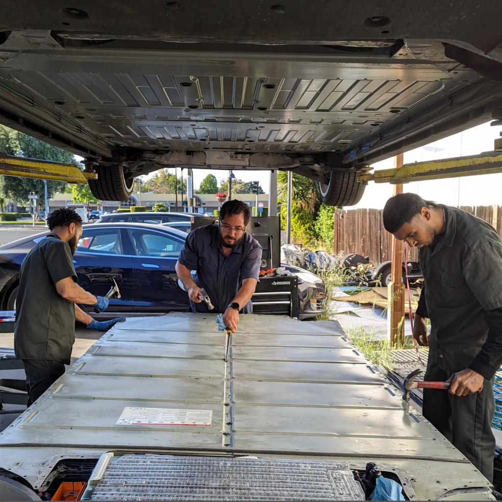 Adam and certified technicians performing Tesla battery repair at Toyota and Tesla Service Center in Santa Clara